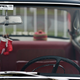 A photo of mini boxing gloves hanging from a rear view mirror.